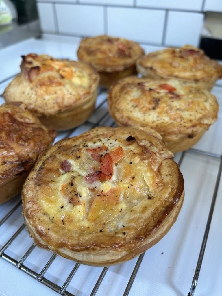 Golden bacon and cheese mini pies cooling on a wire rack
