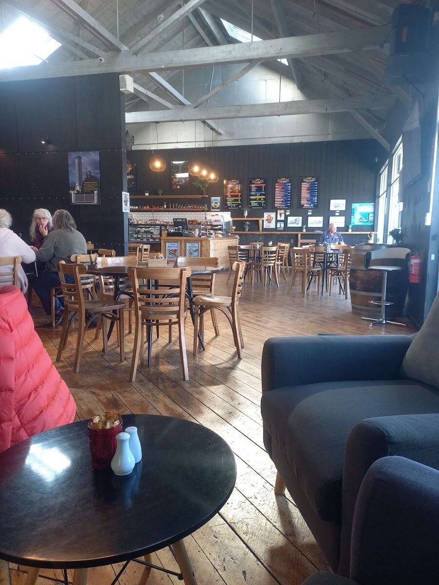 The Coops Cafe room: high trussed ceiling, dark walls, timber floors and locals at the tables